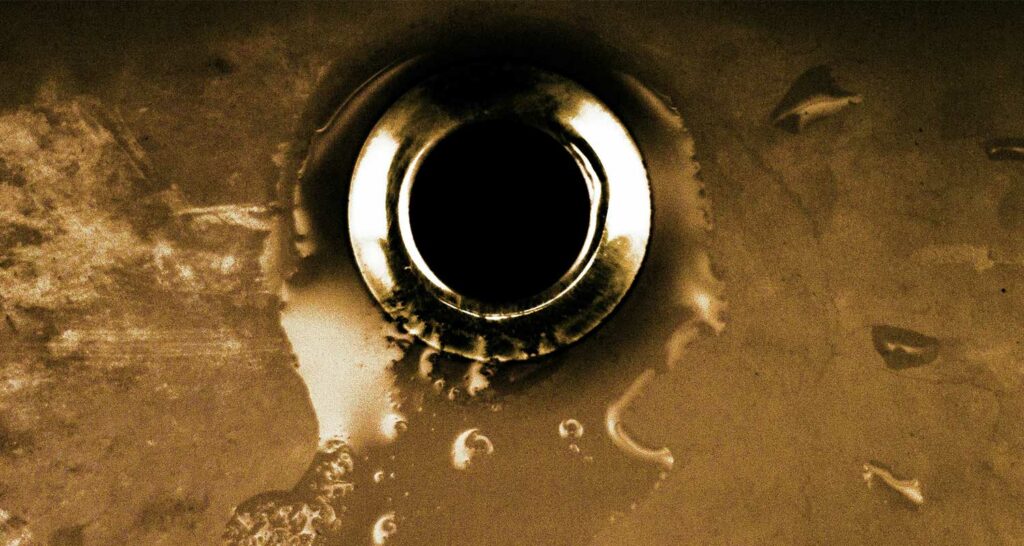 clearing a clogged drain with a plumbing snake