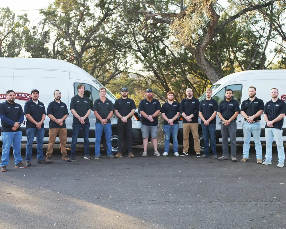 Chambliss Plumbers in San Antonio TX, lined up outside near their commercial vans