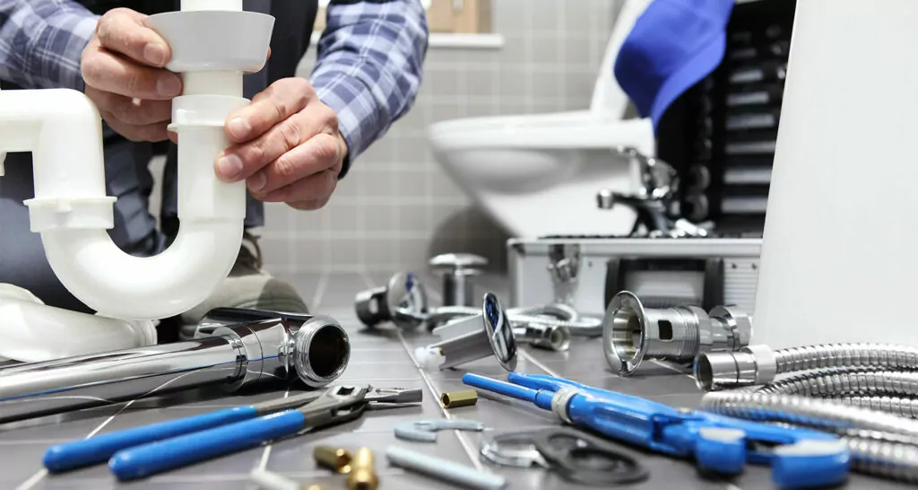 what is a plumber article banner of a man fixing a bathroom pipe